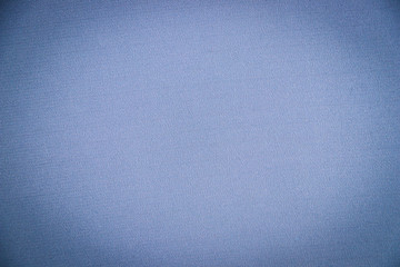 The texture of of light blue canvas fabric as a background. Sateen interlacing of fibers. Close-up. Vignette effect. Background for design and typography.