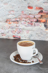 Cup of coffee with cocoa powder forming a heart on the foam