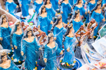 Souvenir figurines of the Yoruba goddess Yemanja stand on display at a street stall at the annual festival dedicated to her in Salvador, Bahia, Brazil