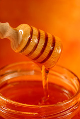 Fototapeta na wymiar Jar with honey and honey wooden dabber 