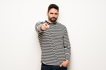 handsome man with striped shirt frustrated by a bad situation and pointing to the front