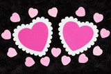 Two blank white and pink hearts on black rose textured plush fabric