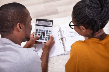 African Couple Calculating Invoice With Calculator
