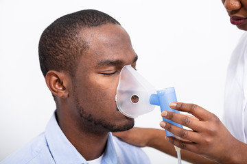 Doctor Placing Inhaler Mask On Man Mouth
