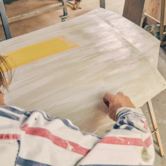 Artist using paint brush for making artificial wood texture.