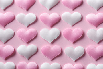 Pink and white textile hearts on pink background. Valentines day texture and love concept