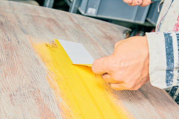 Artist using paint brush for making artificial wood texture.