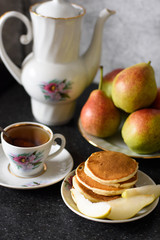 Fresh baked pancakes with pear and tea.