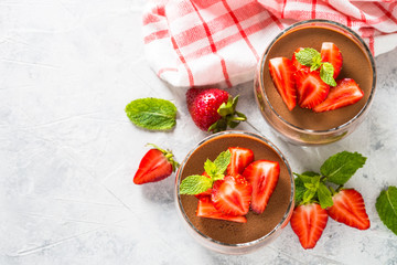 Chocolate panna cotta sweet dessert with strawberries in glass.