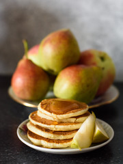 Fresh baked pancakes with honey, pear closeup on concrete background