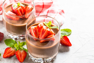 Chocolate panna cotta sweet dessert with strawberries in glass.