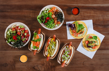 Hawaiian food spread of Poke bowls, hot dogs and fish tacos