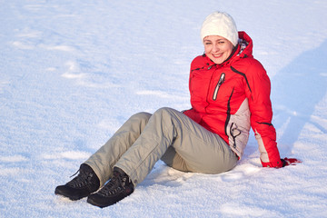Fototapeta na wymiar Beautiful happy girl sitting on the snow winter outdoors.