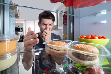 Man Recognizing Bad Smell From The Refrigerator
