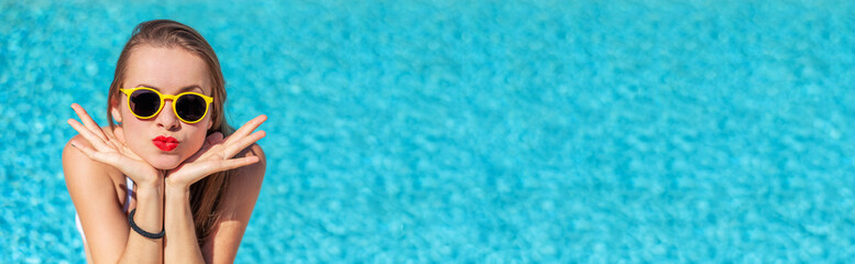Summertime in pool. Young woman with yellow sunglasses in pool.