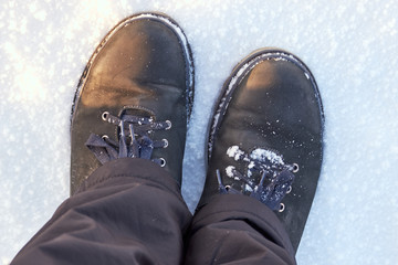 a pair of winter men's boots on white snow top view for background. winter walk in the frost