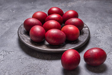 Уggs painted in onion skins in black ceramic plate