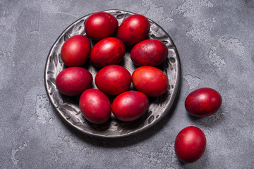 Уggs painted in onion skins in black ceramic plate