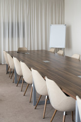Modern meeting room with big table and flipchart