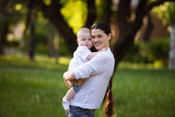 Mom holds a small son in the hands of nature. Walk with the child.