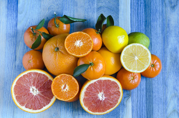 Citrus tangerines oranges lemons lime close-up on blue background