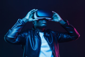 African american man in vr glasses, watching 360 degree video with virtual reality headset isolated on black background © Damir Khabirov