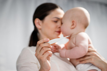 Woman measuring temperature of small sick boy