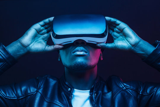 Portrait of African guy isolated on black background wearing headset of virtual reality