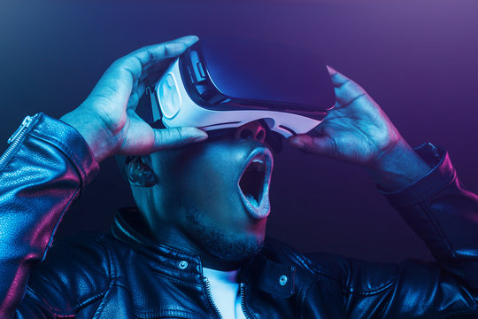 Fototapeta Close-up headshot of excited young african american man enjoying virtual reality with mouth wide open