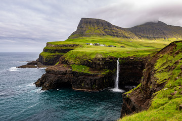 Gasadalur Waterfall at the Faroe Islands in a cloudy day
