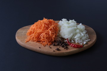 sliced onions and grated carrots on the cutting Board