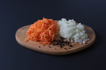 sliced onions and grated carrots on the cutting Board