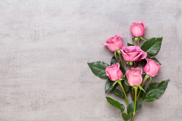 Fototapeta premium Kompozycja walentynki kwiaty. Rama wykonana z różowej róży na szarym tle. Leżał na płasko, widok z góry, miejsce na kopię.