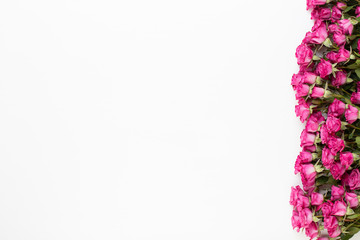 Flowers composition. Frame made of red rose on white wooden background. Flat lay, top view, copy space.