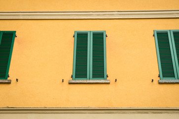 Fototapeta premium Traditional Mediterranean window with closed green shutters, Village in Lake Como, Italy.