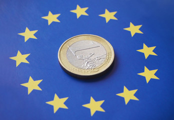 Closeup of a 1 euro coin on top of the European flag