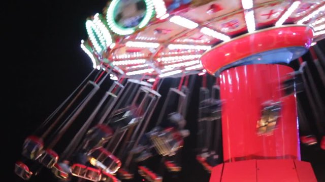 swing funfair fairground swing ride rainbow bokeh lights rides moving flashing people at night
