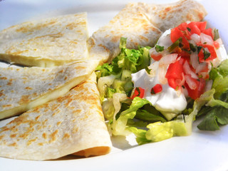 Close-up of mexican quesadillas with cheese and salad. 