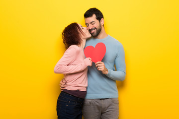 Couple in valentine day holding a heart symbol and kissing