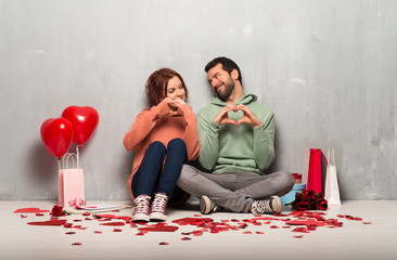 Couple in valentine day making heart symbol by hands