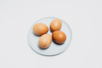 Brown chicken fresh tasty healthy egg on a plate top view. Eggs on a plate on a white background photographed close