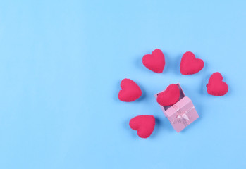 beautiful red hearts in gift box on pastel blue background. Valentines day concept flat lay