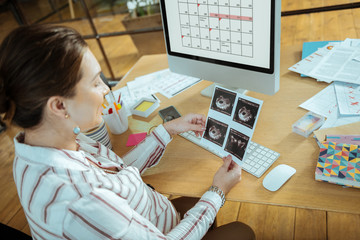 Top view of happy pregnant woman looking at her ultrasound