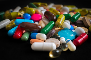Pharmaceutical tablets, capsules, therapy drugs and pills on black background