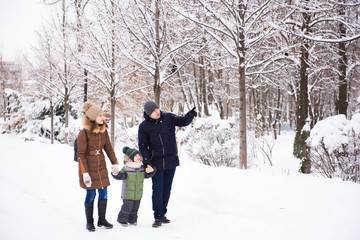 happy family having fun and playing with snow in forest