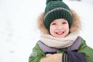 Cute child playing in a snow. Winter activities for kids.