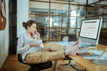 Pregnant employed woman enjoying her lunch break in office