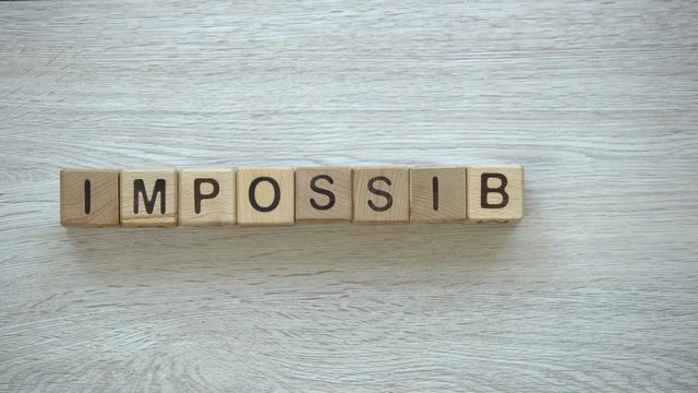 Impossible changes to possible, stop motion word on wooden cubes, possibilities