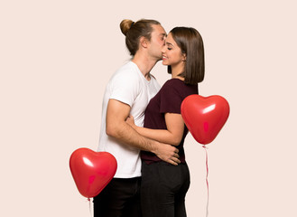 Fototapeta na wymiar Couple in valentine day kissing over isolated background