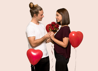 Fototapeta na wymiar Couple in valentine day with flowers over isolated background